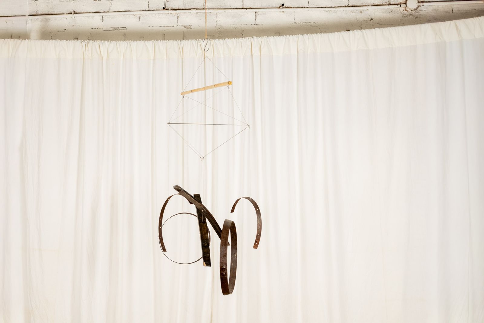 Aros 0011, suspended sculpture of reclaimed wine cask staves and hoops hanging from a cane
