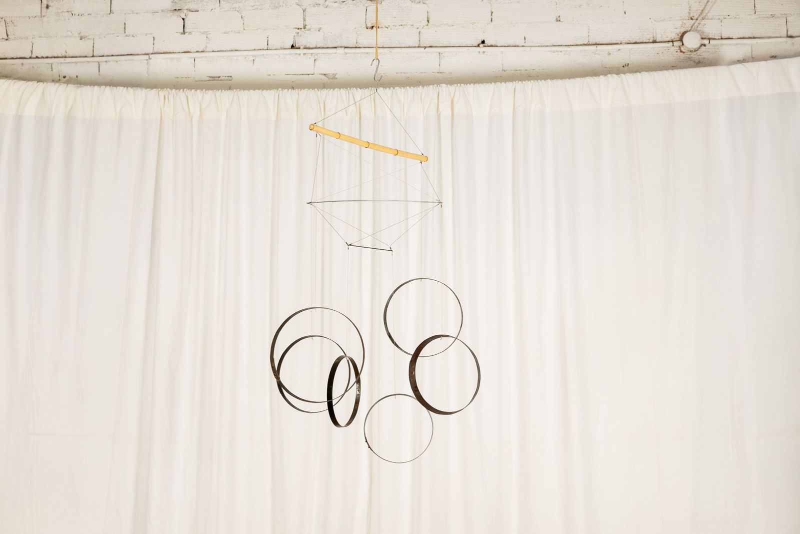 Aros 0012, suspended sculpture of reclaimed wine cask staves and hoops hanging from a cane