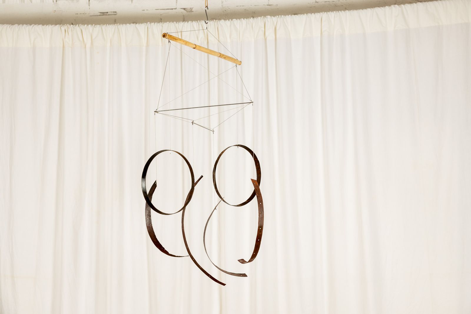 Aros 008, suspended sculpture of reclaimed wine cask staves and hoops hanging from a cane