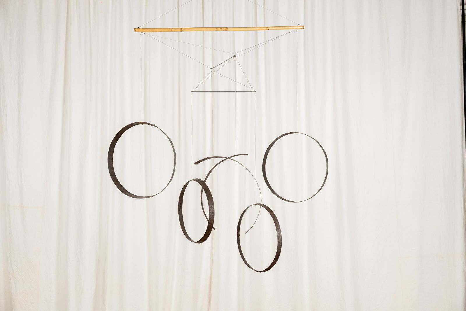 Aros 009, suspended sculpture of reclaimed wine cask staves and hoops hanging from a cane