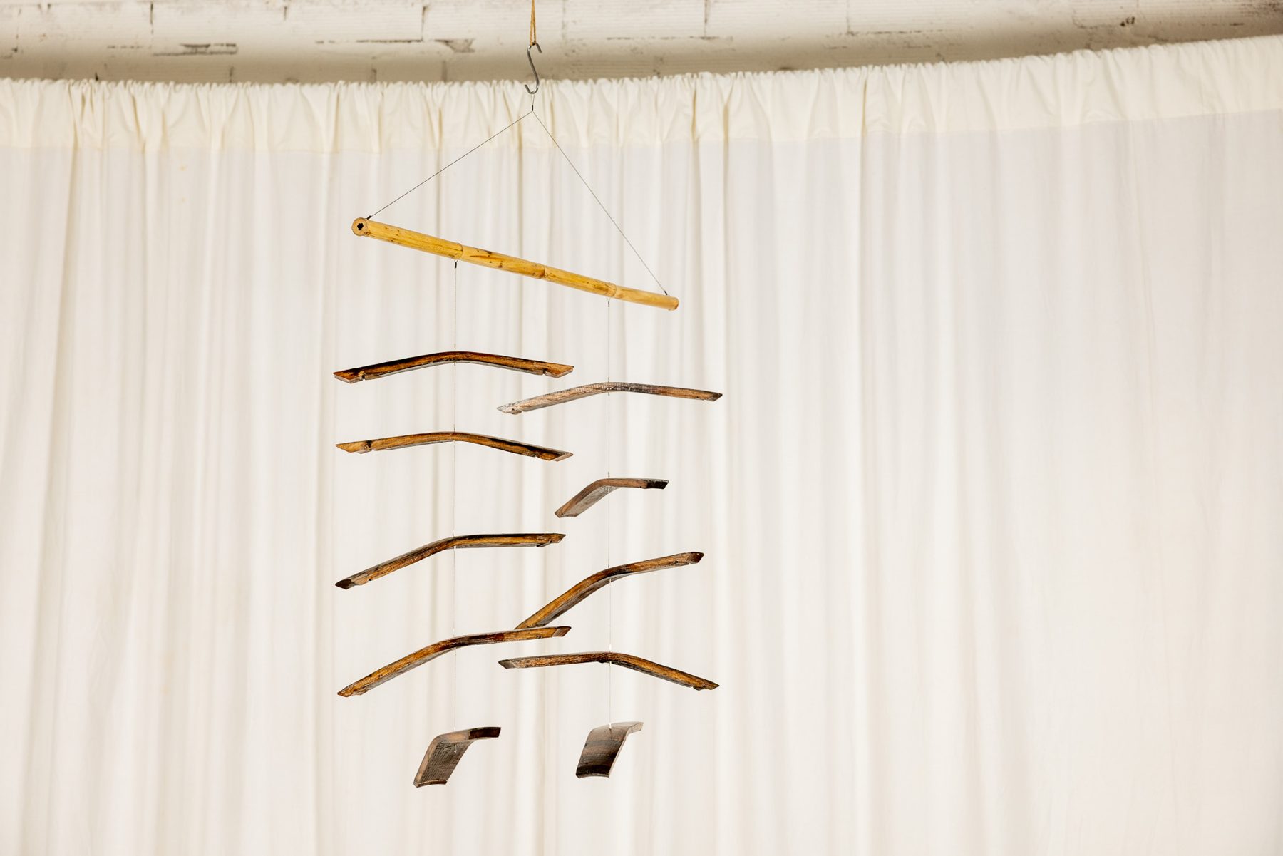 Dogues 0015, suspended sculpture of reclaimed wine cask staves and hoops hanging from a cane