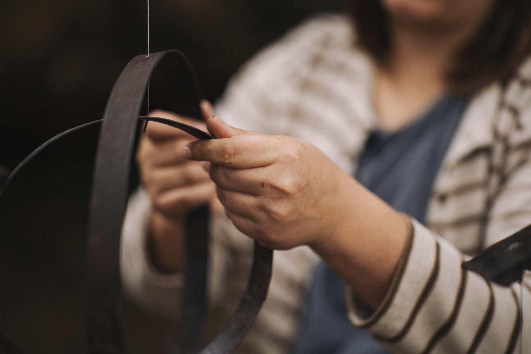 Hands adjusting wine cask hoops
