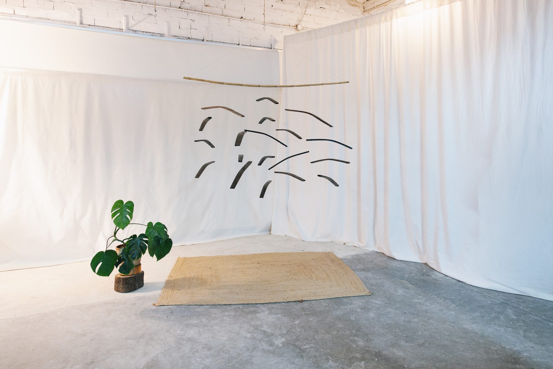 Wine cask staves mobile suspended from a cane in a white studio